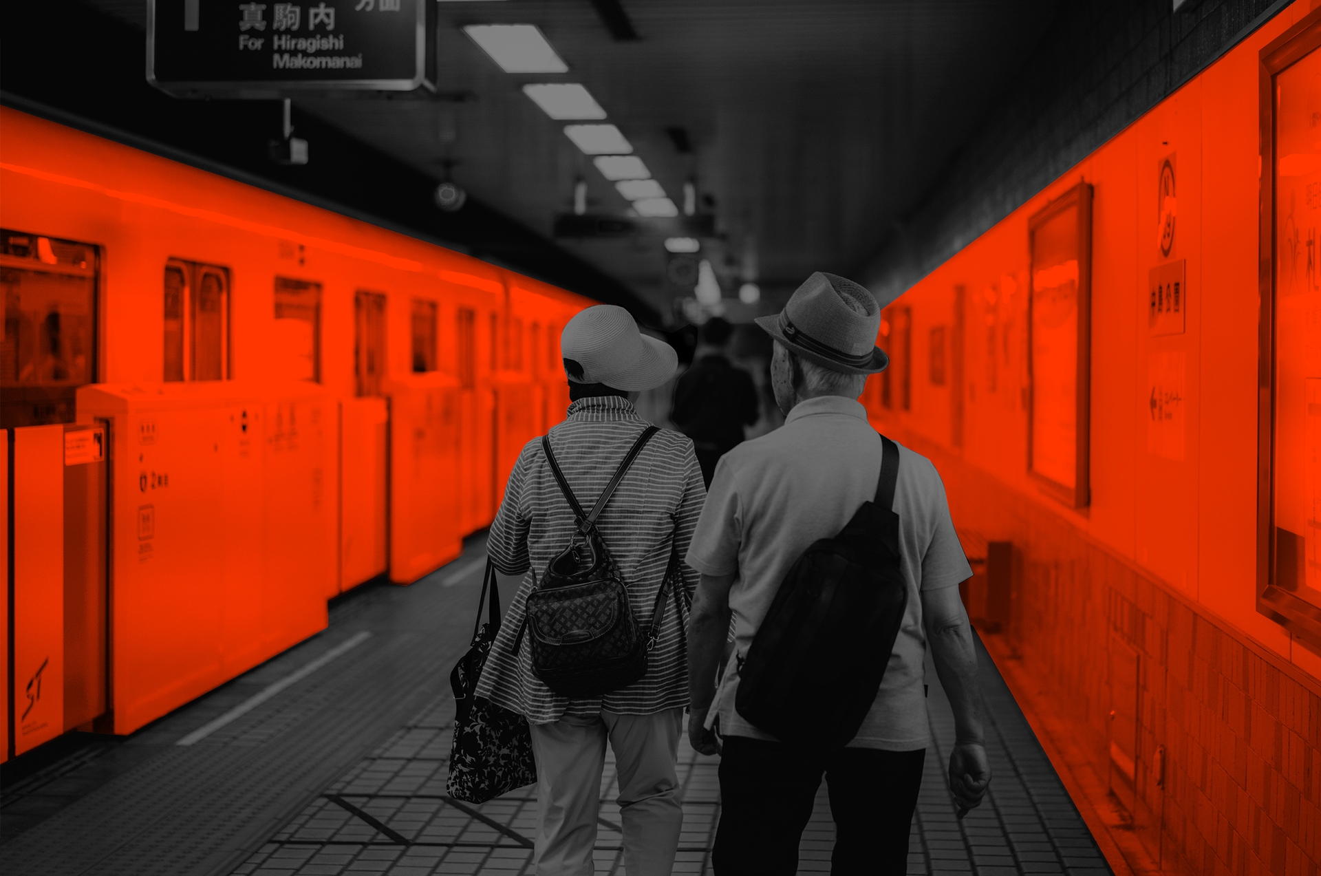 An elderly Japanese woman and man walking on a Sapporo subway platform.